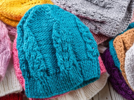 A collection of colorful knitted hats showcasing a variety of textures and patterns. 