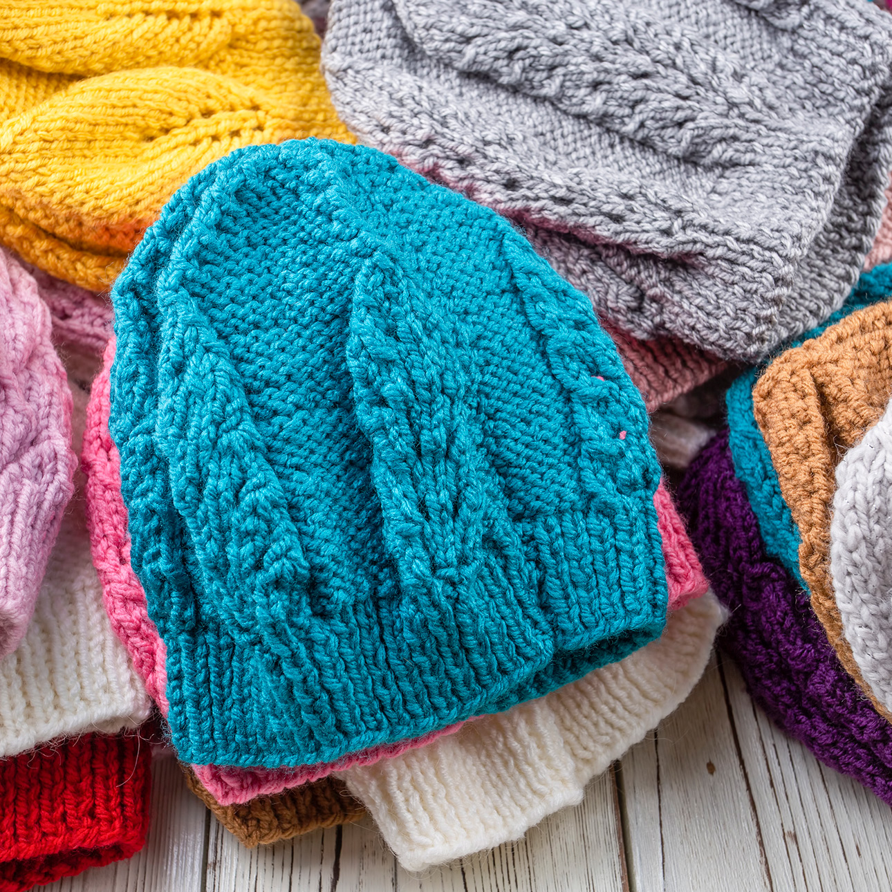 A collection of colorful knitted hats showcasing a variety of textures and patterns. 