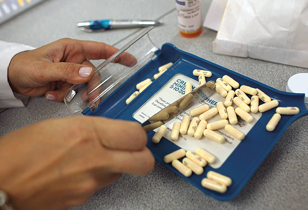Pharmacy manager counts out the correct number of antibiotic pills. Photo: Joe Raedle/Getty Images
