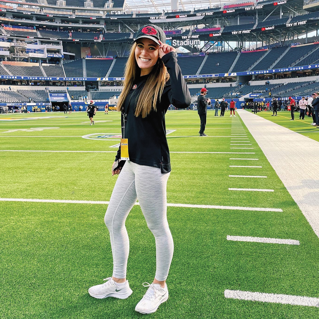 Emma Steinberg poses with her hat on a football field.