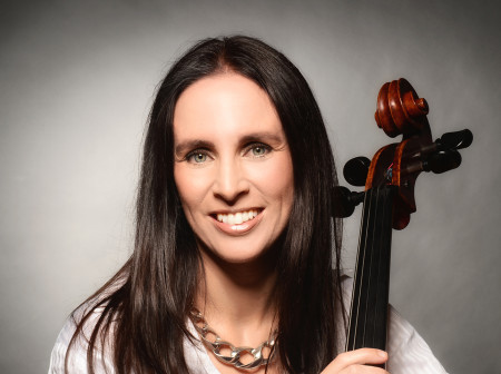 Racheli Galay poses with her cello, smiling.