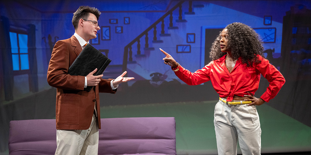 Two characters from the show Dot’s Home Live converse onstage. On the left is Mr. Murphy, a white man wearing a brown suit jacket and tan slacks and holding a black folder. On the left is Dot, a Black woman wearing a red top and white pants, pointing her finger at Mr. Murphy.