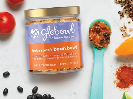 A jar of Globowl baby food alongside a small spoon and assorted food items.
