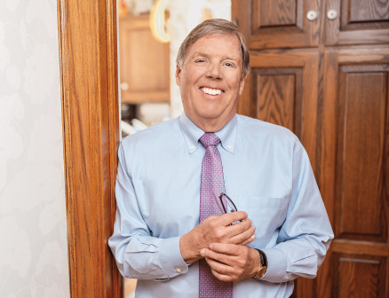 T. Bondurant “Bon” French stands in doorway smiling at the camera.