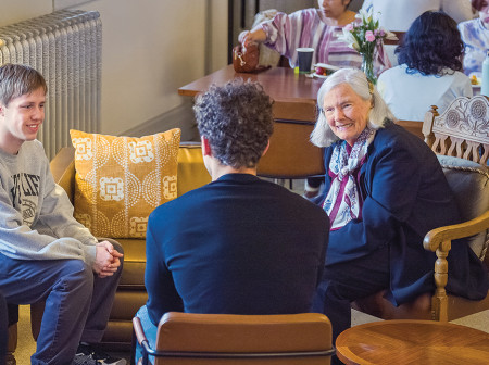 Roberta Buffett Elliott sits down with four students for a conversation indoors.