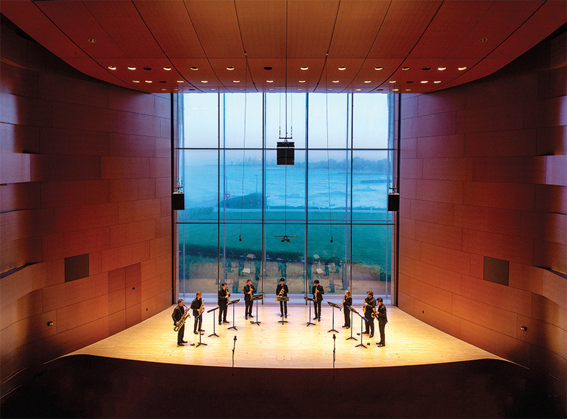 Nine people play instruments on stage at the Mary B. Galvin Recital Hall.