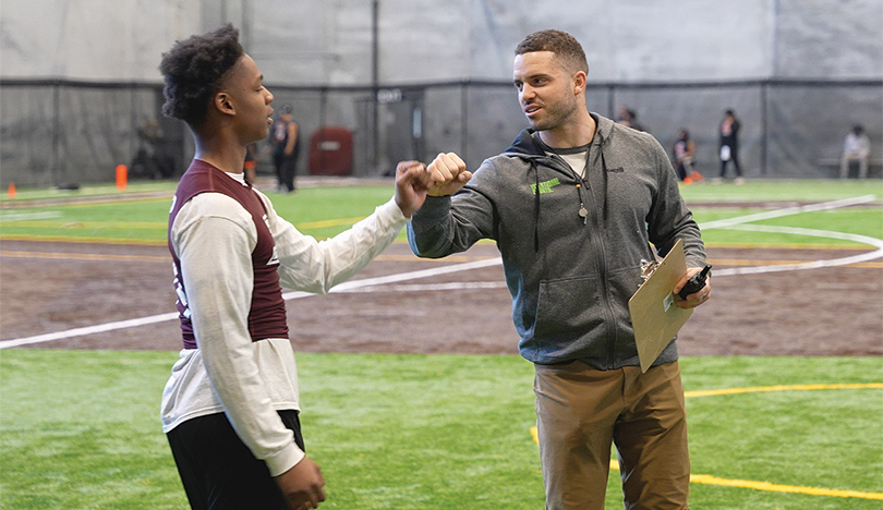 Austin Carr fist-bumps an Intentional Sports participant on an indoor soccer field.