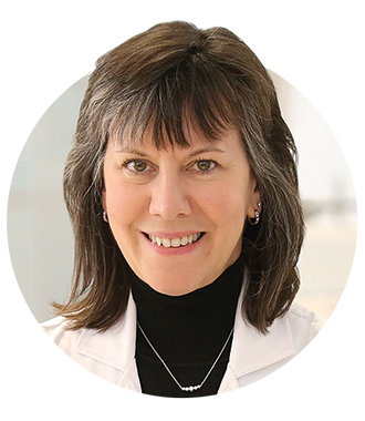 A headshot of Elizabeth McNally in a lab coat and black turtleneck 