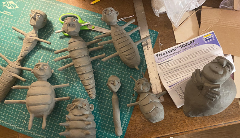 Unfinished clay-colored molds of the film’s bug characters lie on a drafting table.