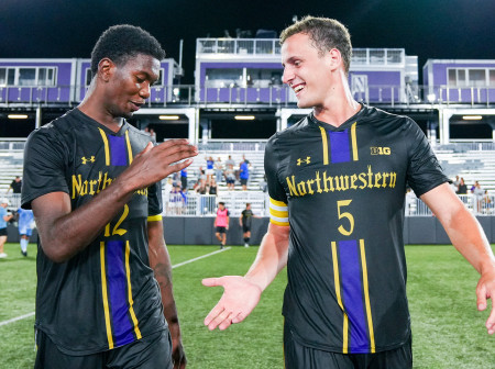 Clad in black Northwestern jerseys, Nigel Prince and Reese Mayer offer each other a low-five. 