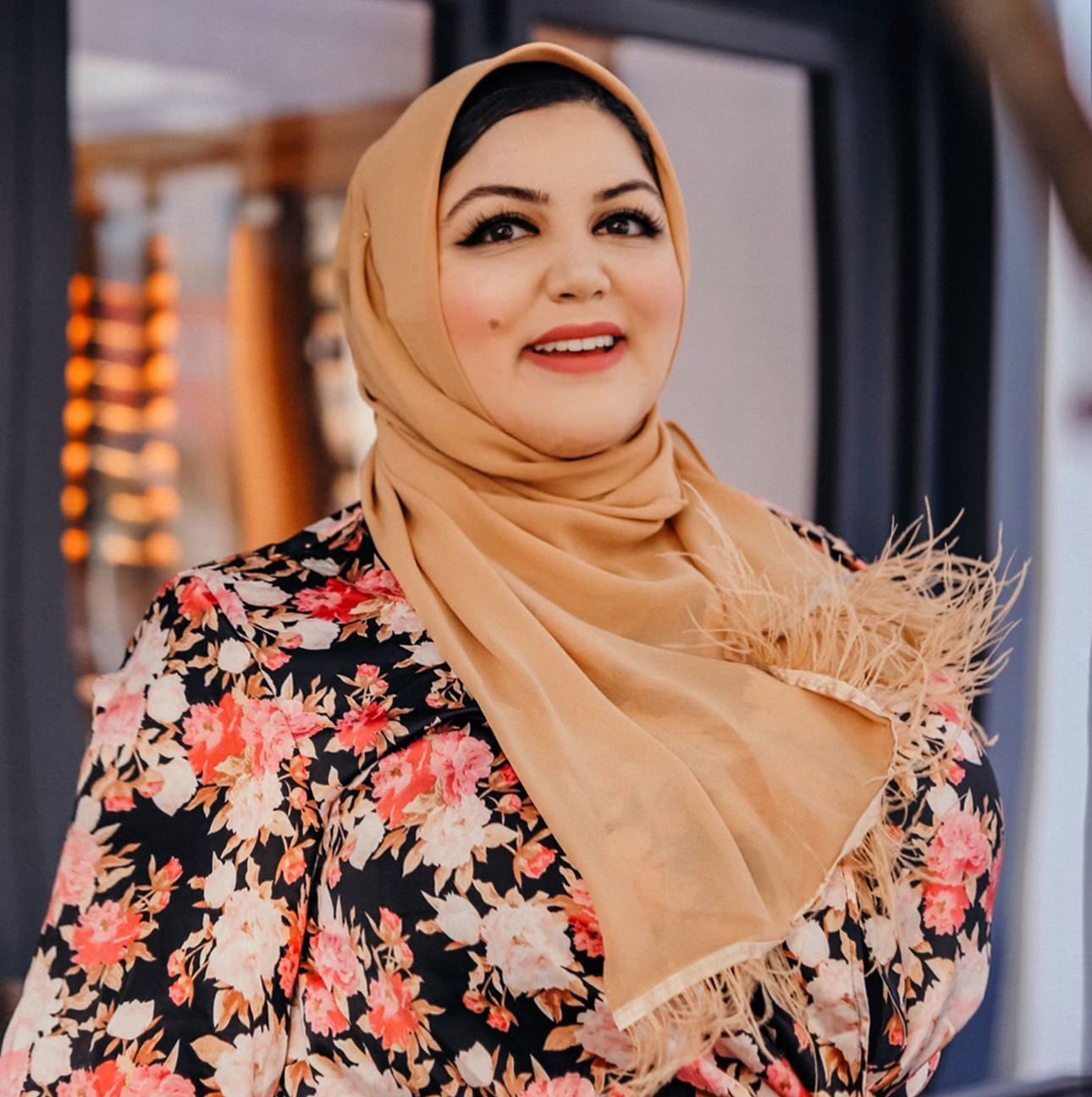 Iman Sediqe standing outside in front of a storefront, smiling for the camera.