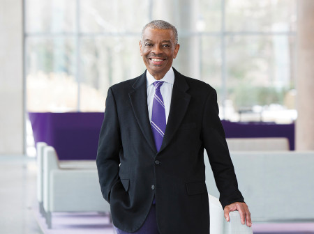 James Hill smiles, standing in the middle of a room.