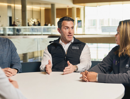 Matt Caldwell and three other people sit and talk at a table in Northwestern’s Global Hub.