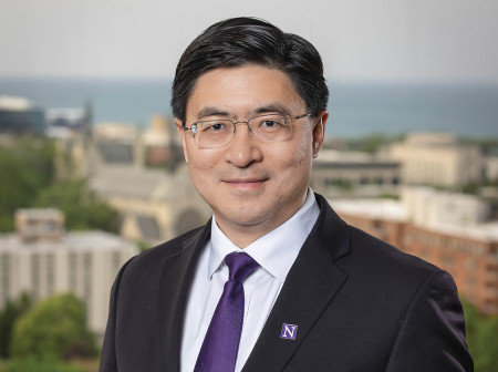 Mung Chiang poses in front of a blurred landscape background. 
