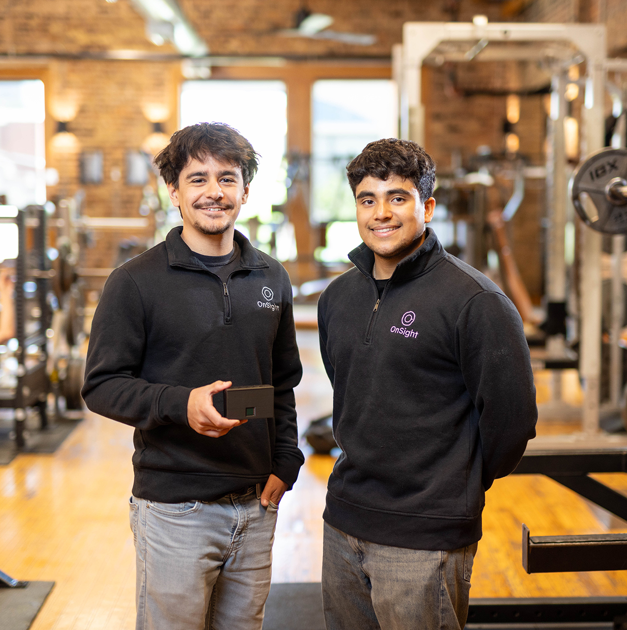 Two men stand in a gym.
