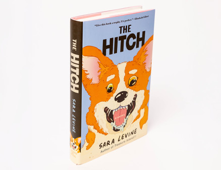 A photo of Sara Levine’s novel The Hitch, with an illustration of an excited orange corgi on the cover.