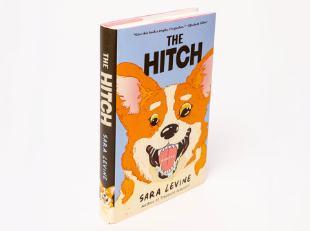 A photo of Sara Levine’s novel The Hitch, with an illustration of an excited orange corgi on the cover.