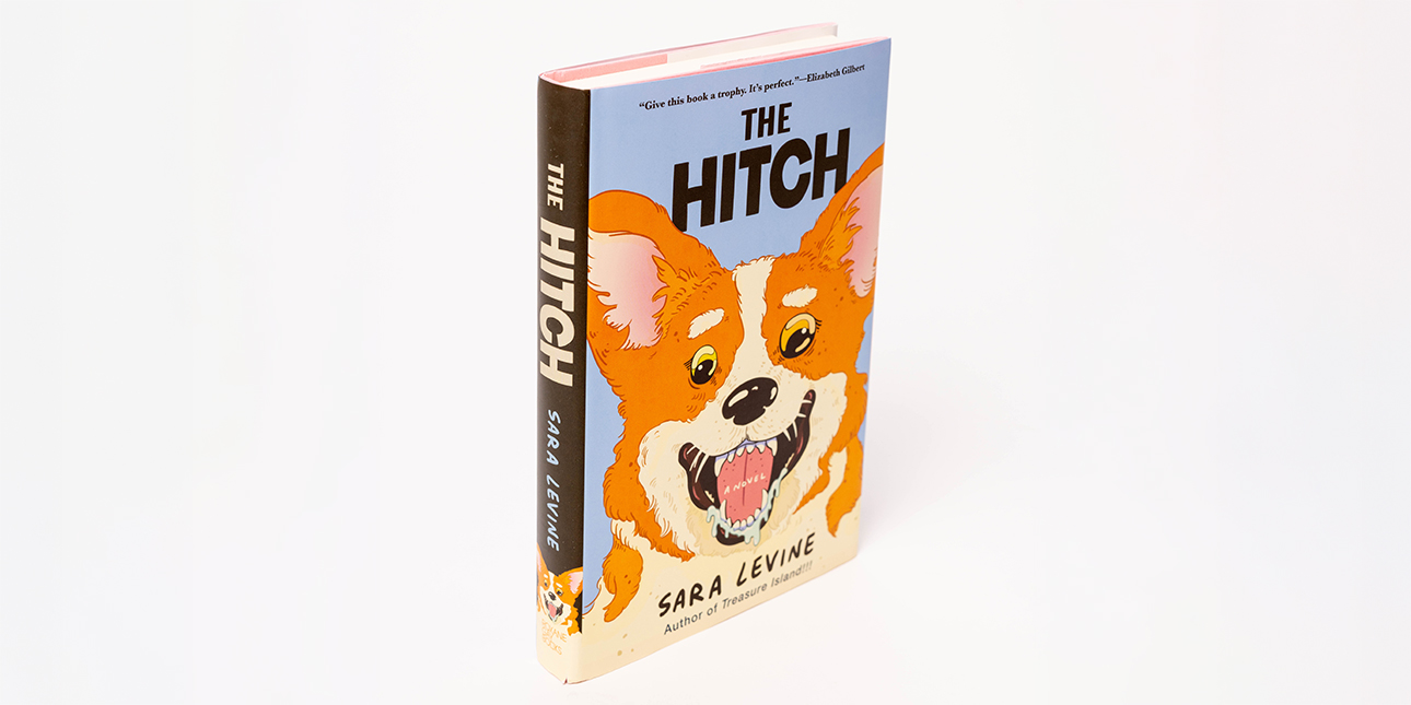 A photo of Sara Levine’s novel The Hitch, with an illustration of an excited orange corgi on the cover.