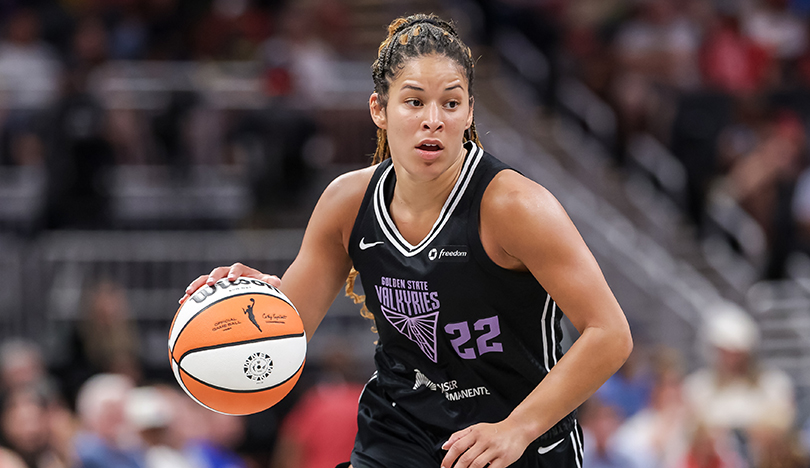 Dressed in a black Valkyries uniform, Veronica Burton dribbles the basketball down the court.