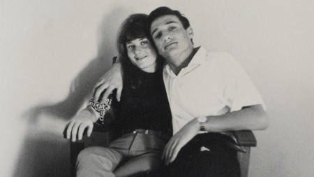 A black and white photograph of Joel and Margalit as a young couple, sitting in a chair together.