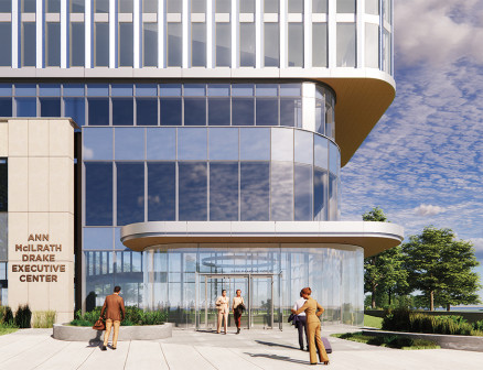 A glass building with a tan front that reads “Ann McIlrath Drake Executive Center.”
