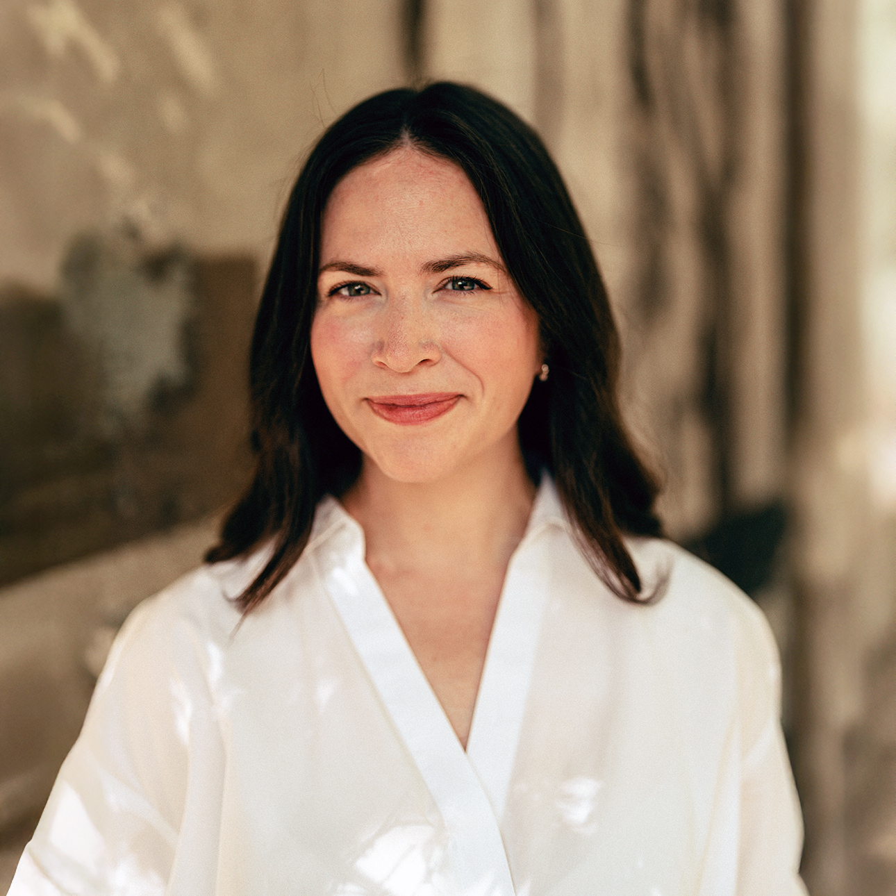 Alexandra Sifferlin smiles for the camera wearing a white blouse