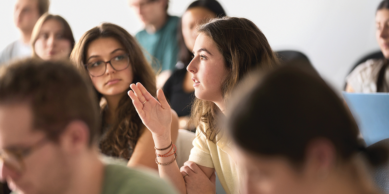 A student speaks as her peers listen inside a classroom.