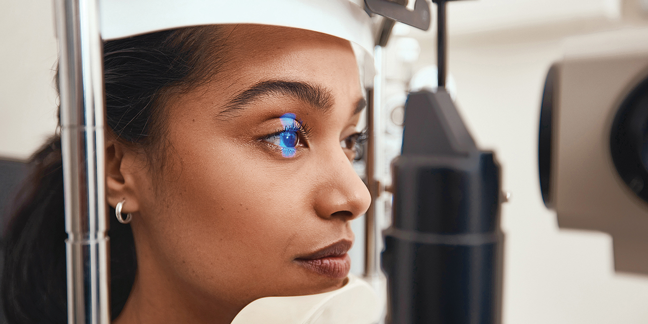 A woman has her eye scanned in a clinic