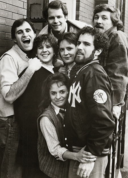 A black-and-white photo of a group of actors posting together, including Richard Kind. 
