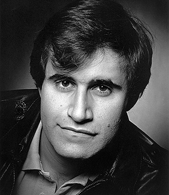 A black-and-white headshot of a young Richard Kind 