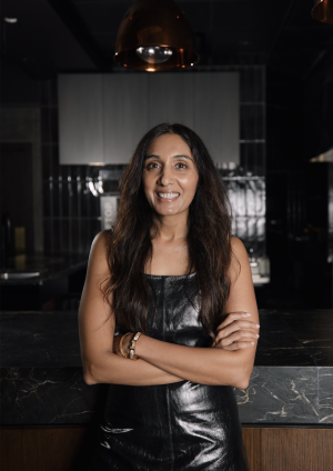 Headshot of Shreena standing with a smile in her restaurant.