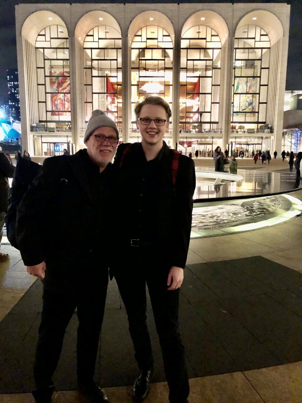 Kevin Vondrak standing with Donald Nally in front of Lincoln Center, NYC with their arms on each others shoulders